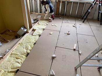 床への断熱材（グラスウール）敷き込み施工の様子
