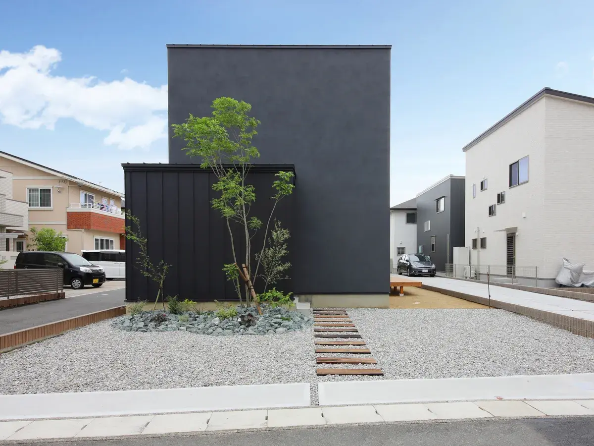 黒いキューブ型の外観と砂利と植栽