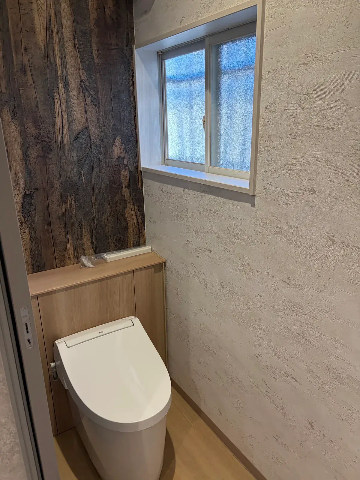 古材風のアクセント壁を張ったトイレ