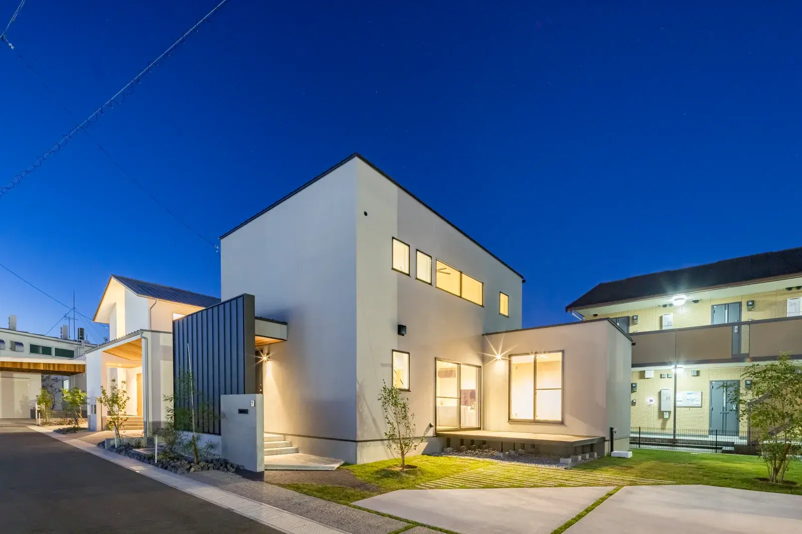 夕景に窓が灯る、白と黒の2階建て 施工写真 2